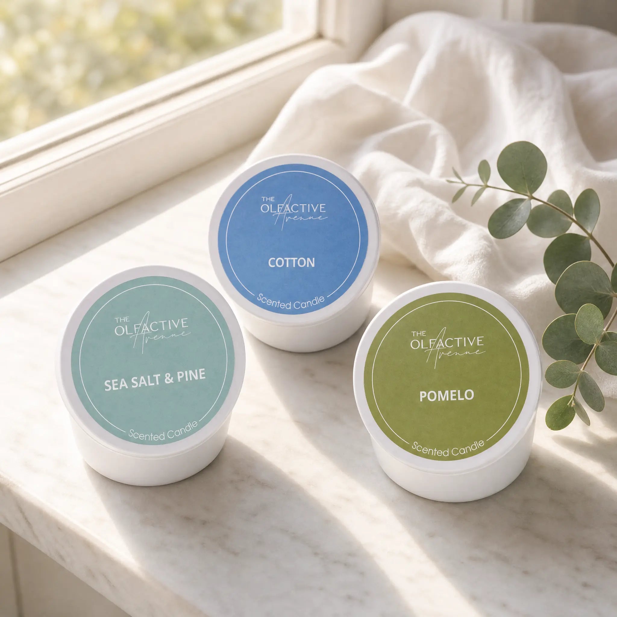 Mini Duftkerzen Bundle von The Olfactive Avenue mit Pomelo, Cotton und Sea Salt & Pine in puristischer Produktaufnahme. Das Travel Candle Set eignet sich für frische Duftmomente, als Geschenkidee und zum Testen hochwertiger Duftkerzen.