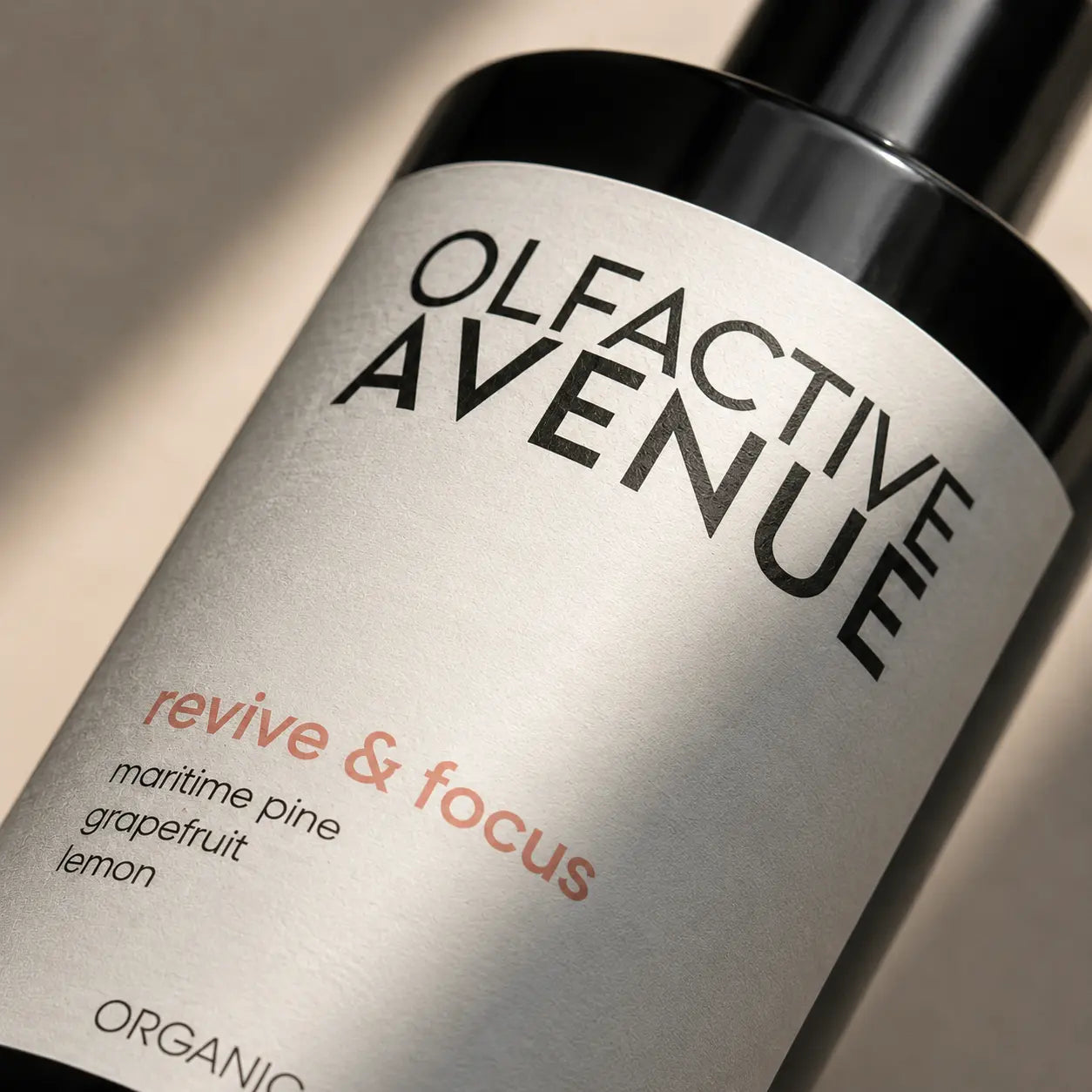 Detailaufnahme des Revive & Focus Raumsprays von The Olfactive Avenue mit natürlichem Licht und elegantem Produktetikett.