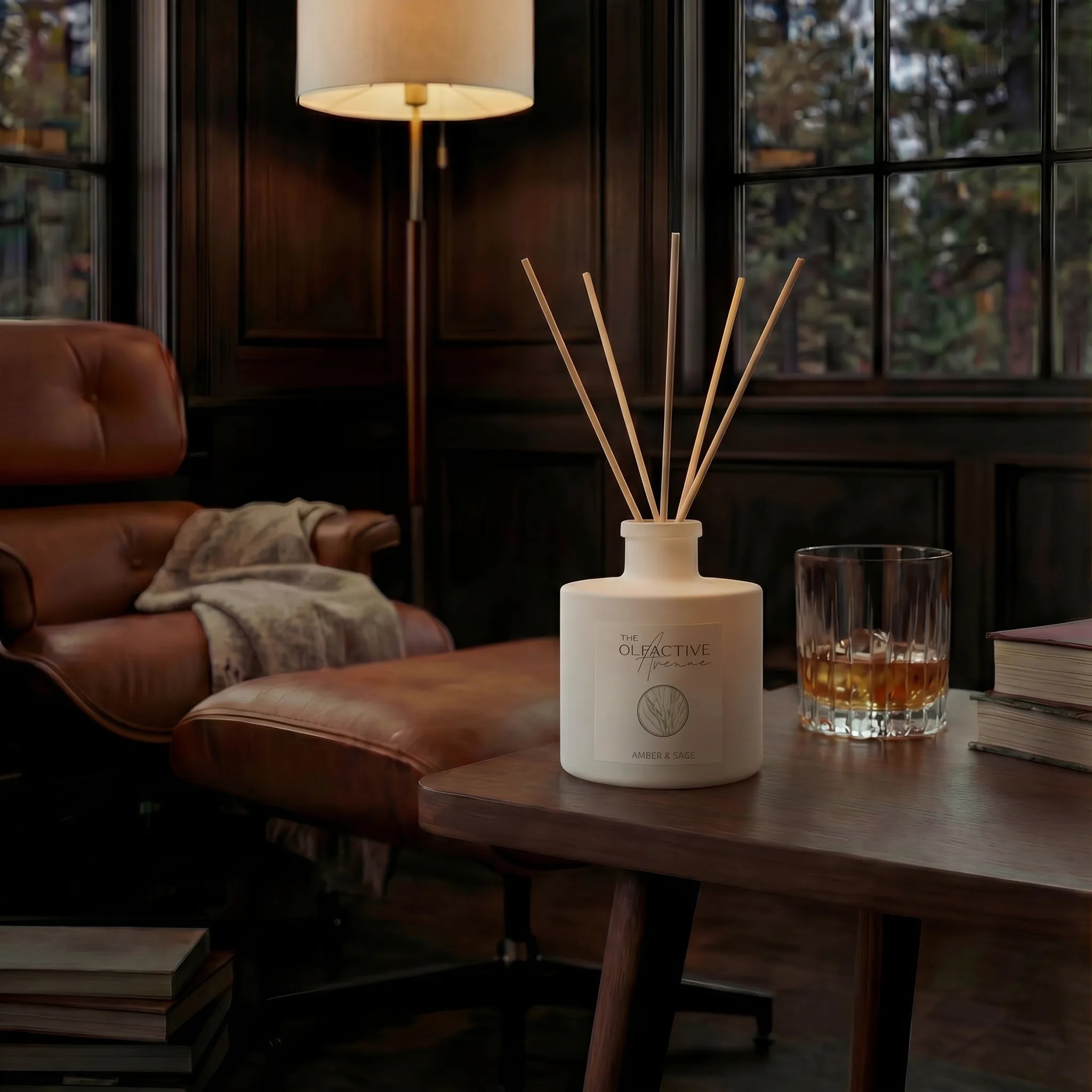 Raumduft Amber & Sage von The Olfactive Avenue auf einem Schreibtisch mit Whisky-Glas und Buch – Atmosphère Entspannung. [KI]