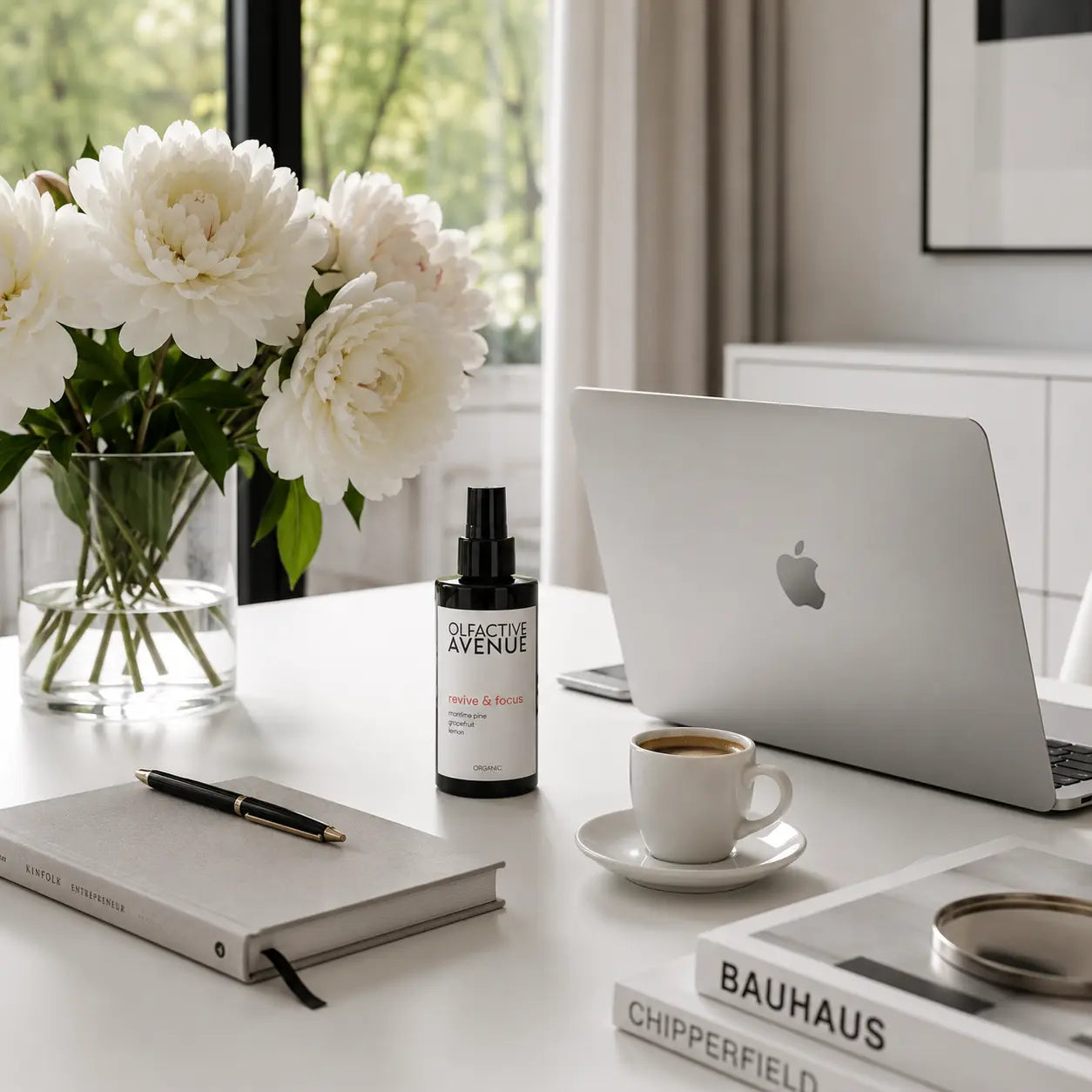 Revive & Focus Bio-Raumspray von The Olfactive Avenue auf einem hellen Schreibtisch mit Laptop, Kaffee und Blumen.