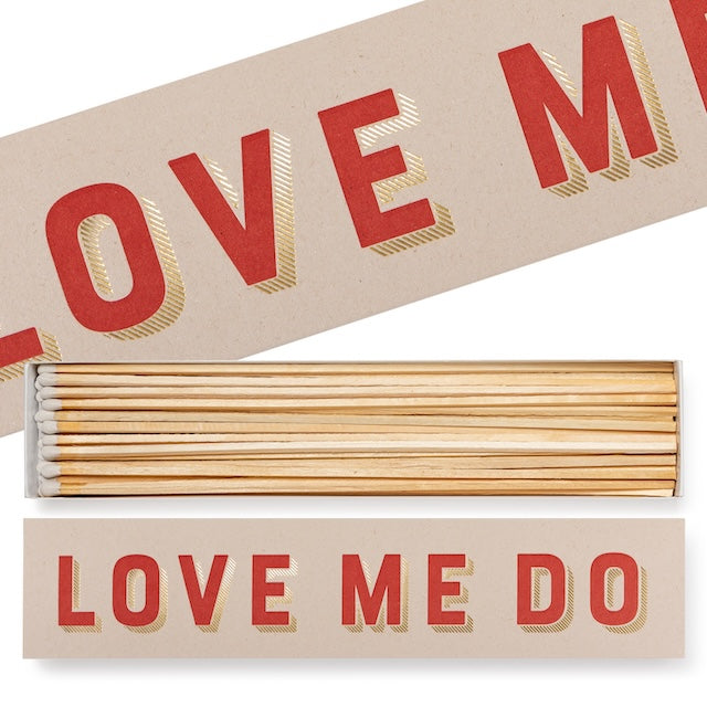 Long Matchbox „Love Me Do“: beige Box mit roter Typo & Goldfolie; 45 extra-lange Streichhölzer (30 cm) mit weißen Köpfen.