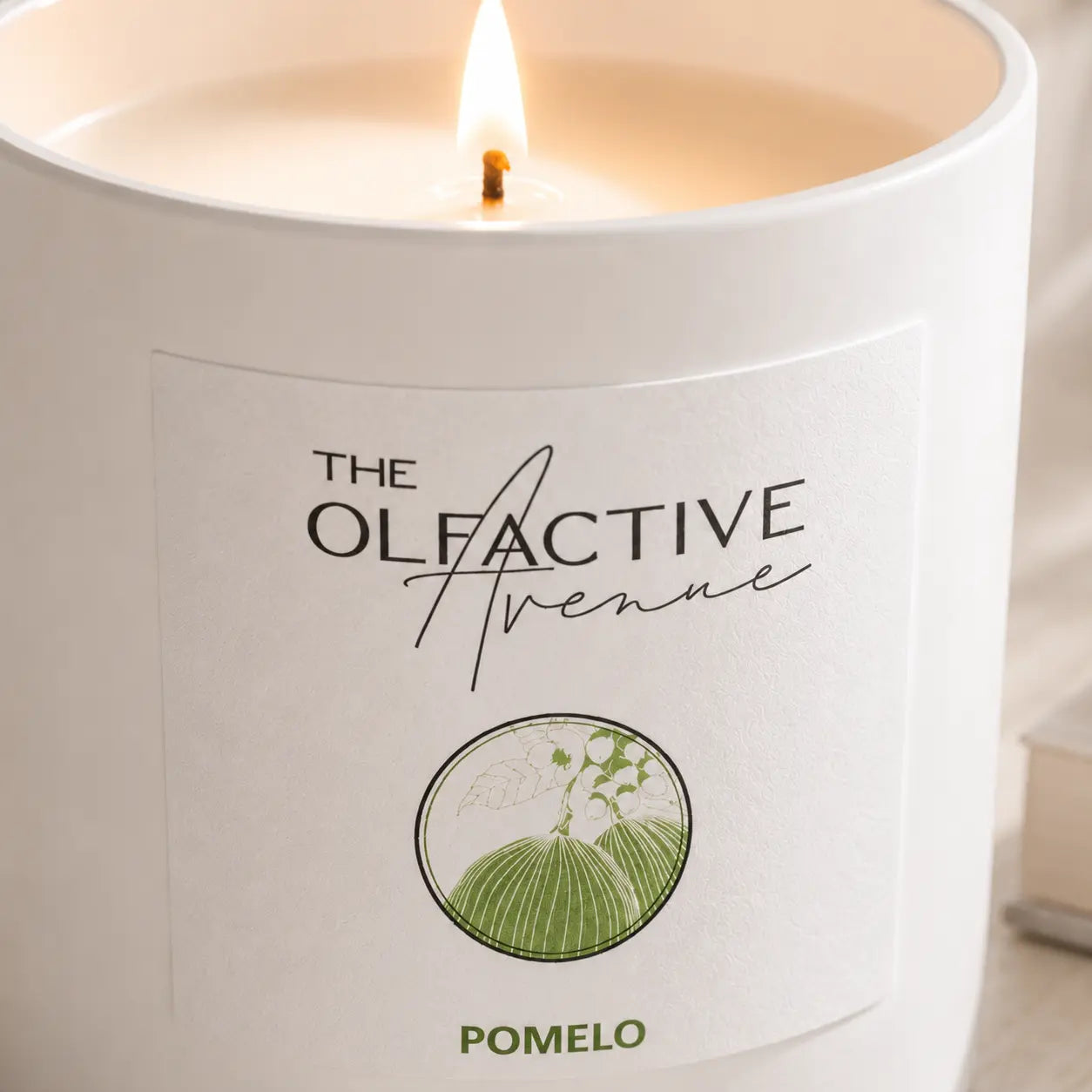 Duftkerze Pomelo von The Olfactive Avenue — Labeldetail mit heller Flamme und Zitrusduft