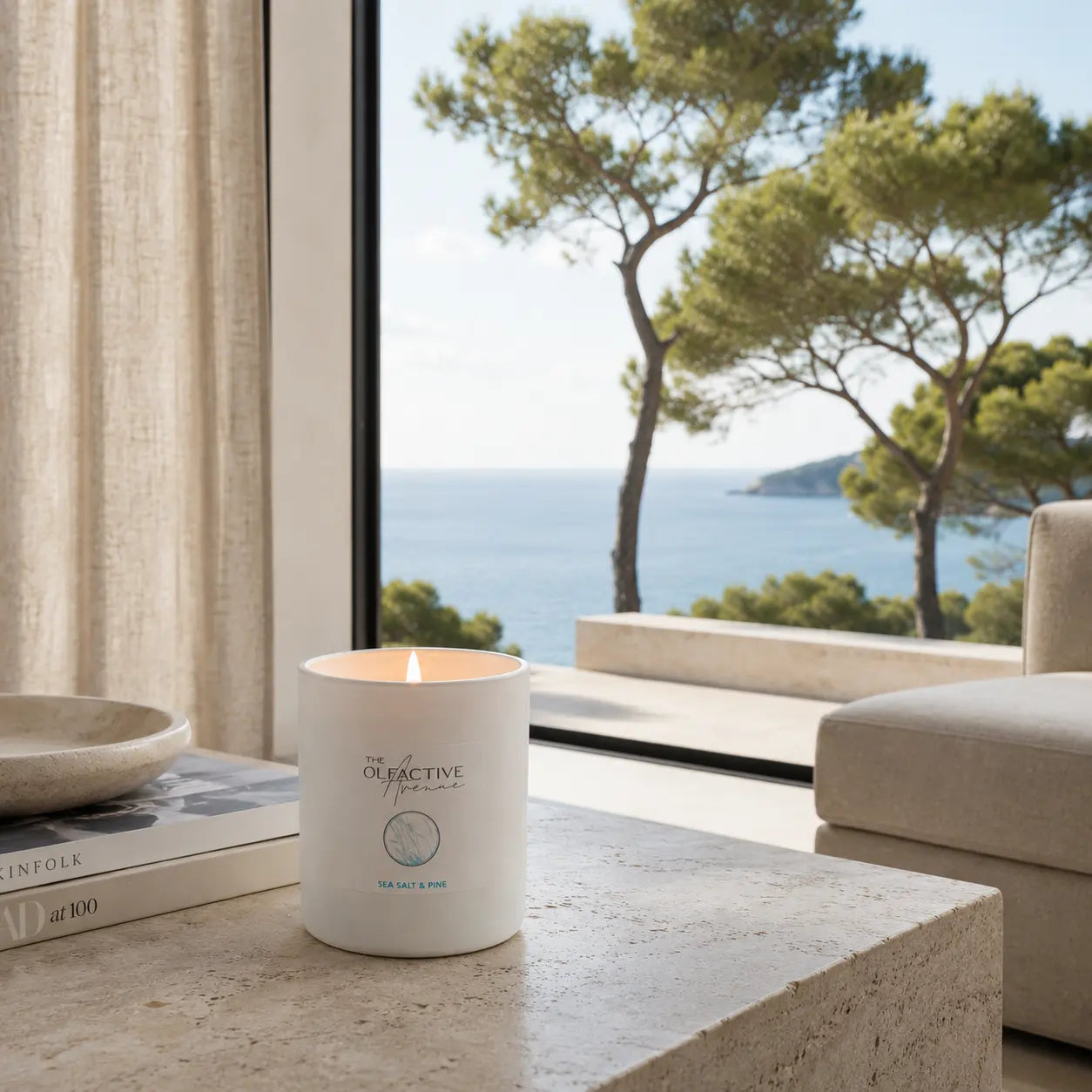 Duftkerze Sea Salt & Pine von The Olfactive Avenue — brennend im Wohnambiente mit Meerblick