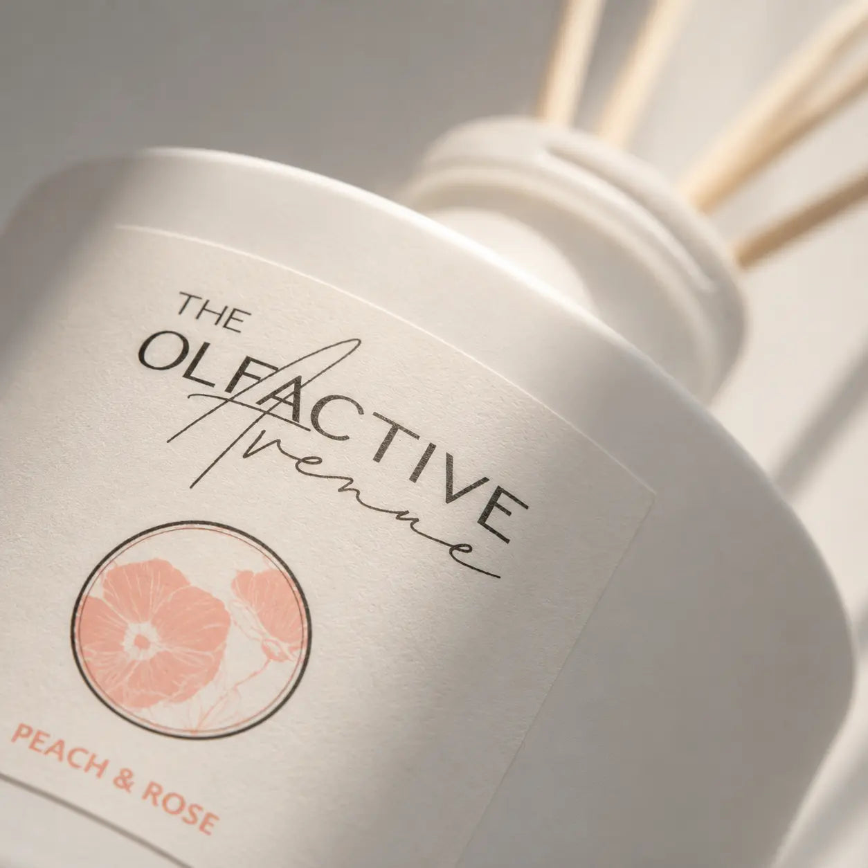 Raumdiffuser Peach & Rose von The Olfactive Avenue — Nahaufnahme von Label und mattem Glas. [KI]