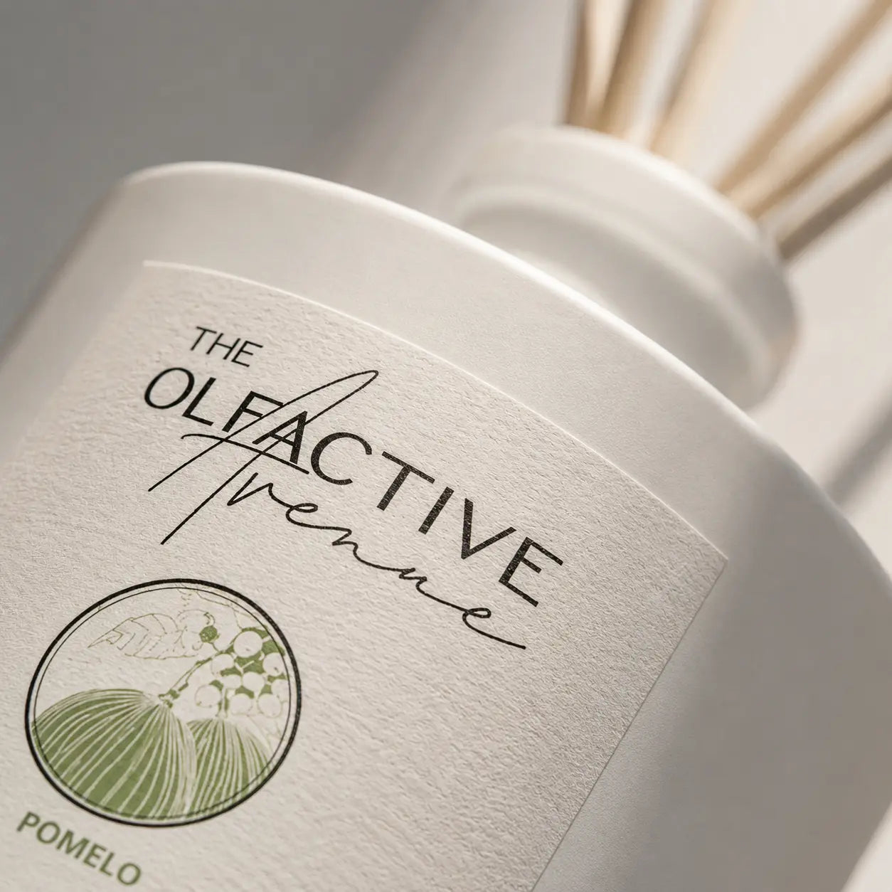Raumdiffuser Pomelo von The Olfactive Avenue — Nahaufnahme von Label, mattem Glas und Duftstäbchen