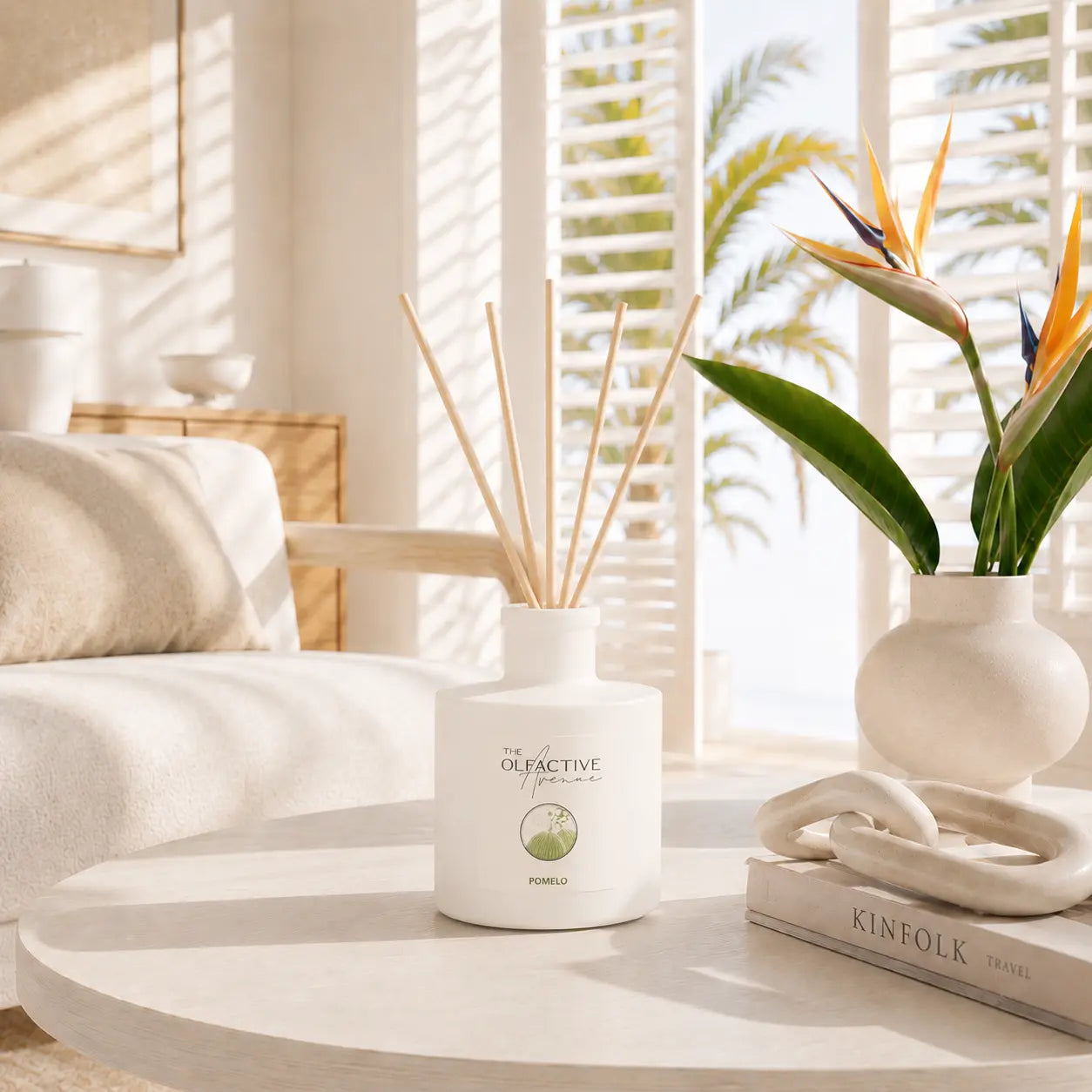 Raumdiffuser Pomelo von The Olfactive Avenue auf hellem Couchtisch in luxuriösem Wohnzimmer mit tropischer Pflanze