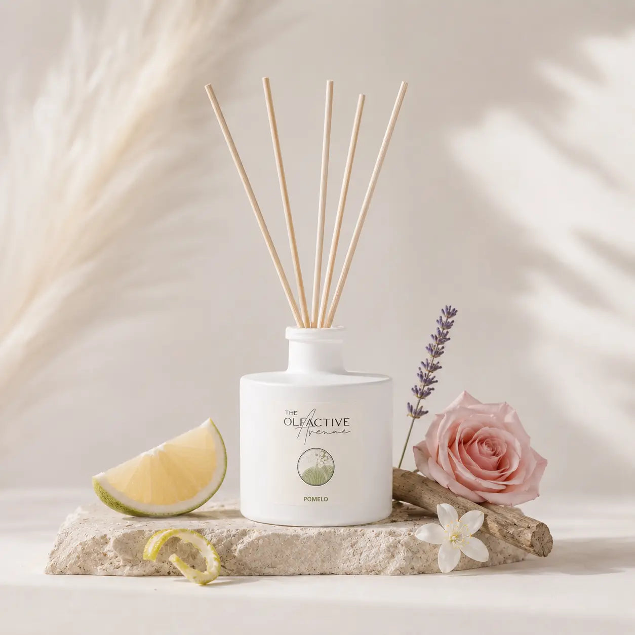 Raumdiffuser Pomelo von The Olfactive Avenue mit Zitrusfrucht, Lavendel und Rose auf hellem Naturstein