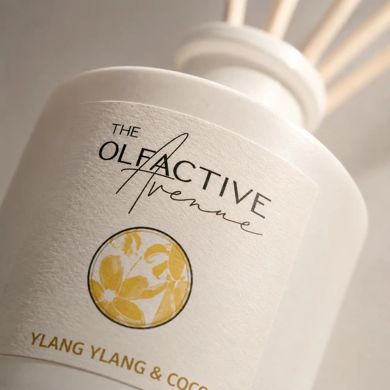 Detailaufnahme des Ylang Ylang & Coco Raumdiffusers von The Olfactive Avenue mit floralem Etikett und warmem Premium-Look. [KI]