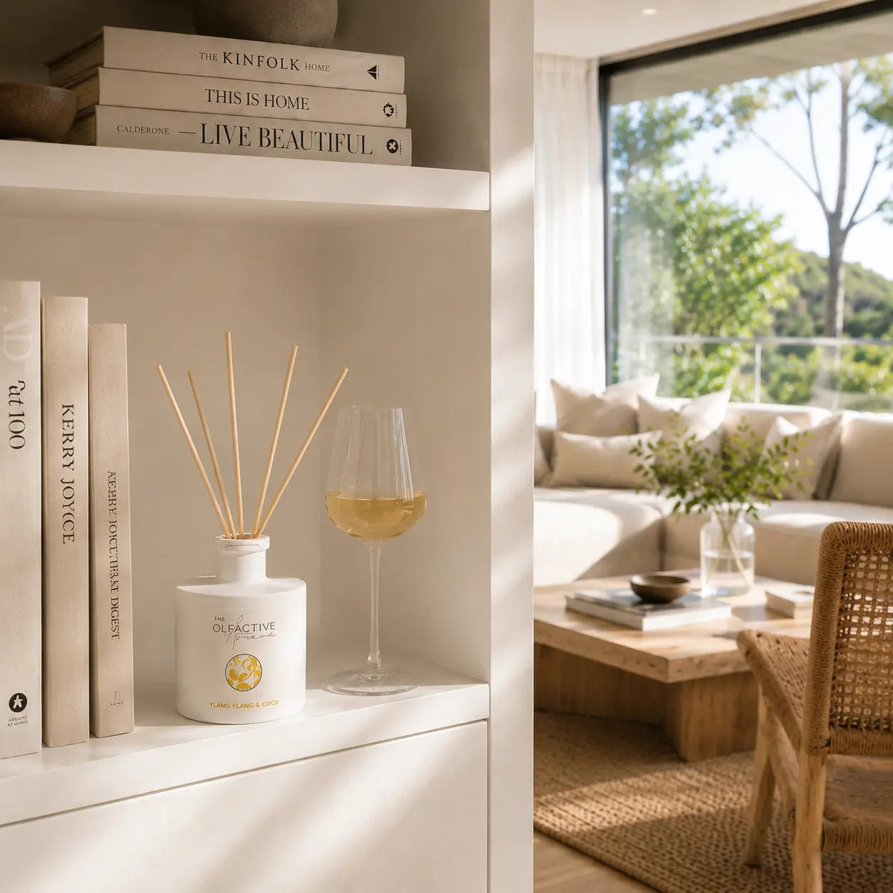 Ylang Ylang & Coco Raumduft von The Olfactive Avenue im hellen Regal mit Designbüchern und sonnigem Wohnzimmer-Ambiente. [KI]